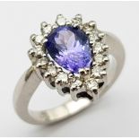An 18 K white gold ring with a pear cut tanzanite (1.71 carats) surrounded by a halo of diamonds,