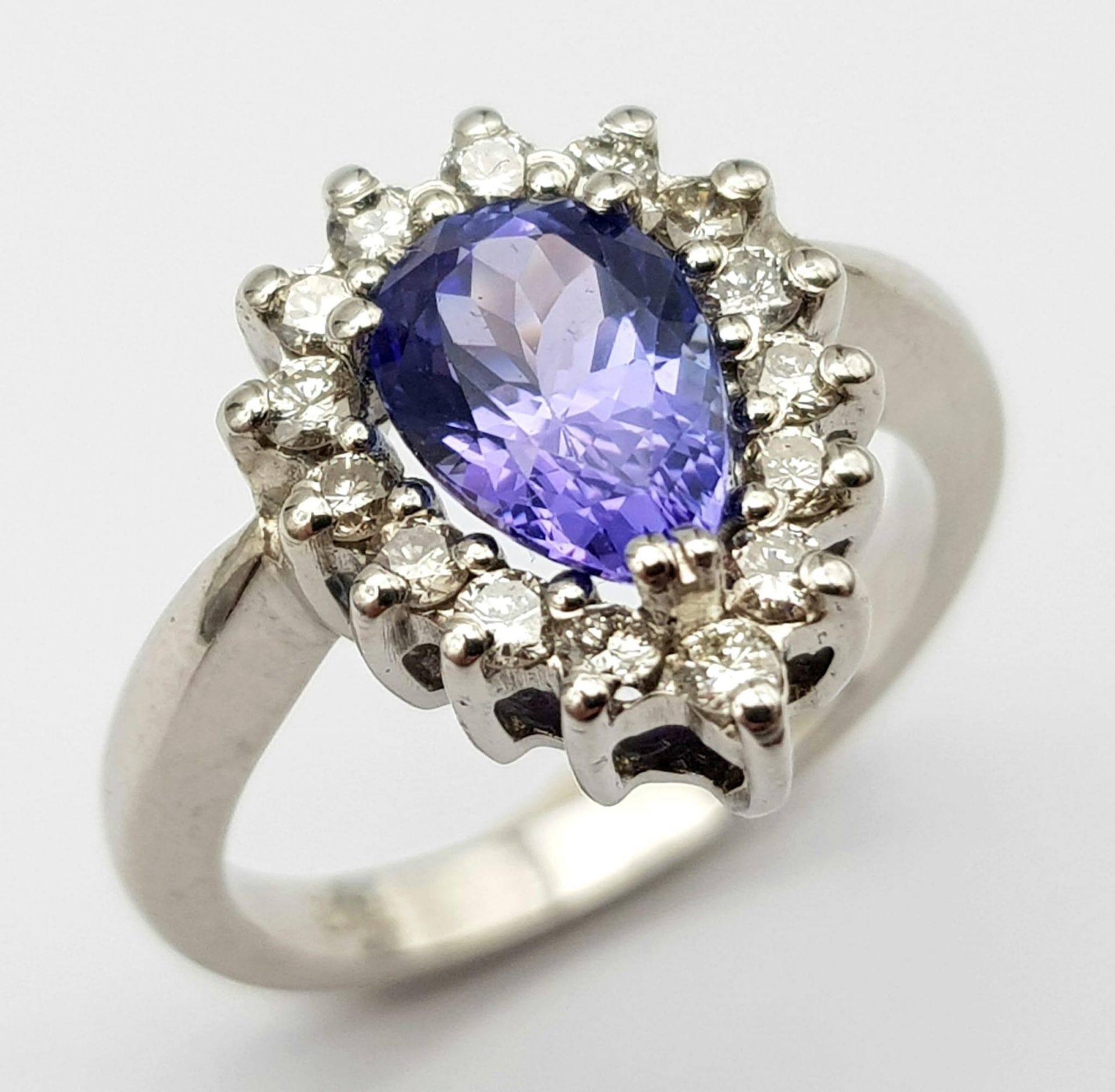 An 18 K white gold ring with a pear cut tanzanite (1.71 carats) surrounded by a halo of diamonds,