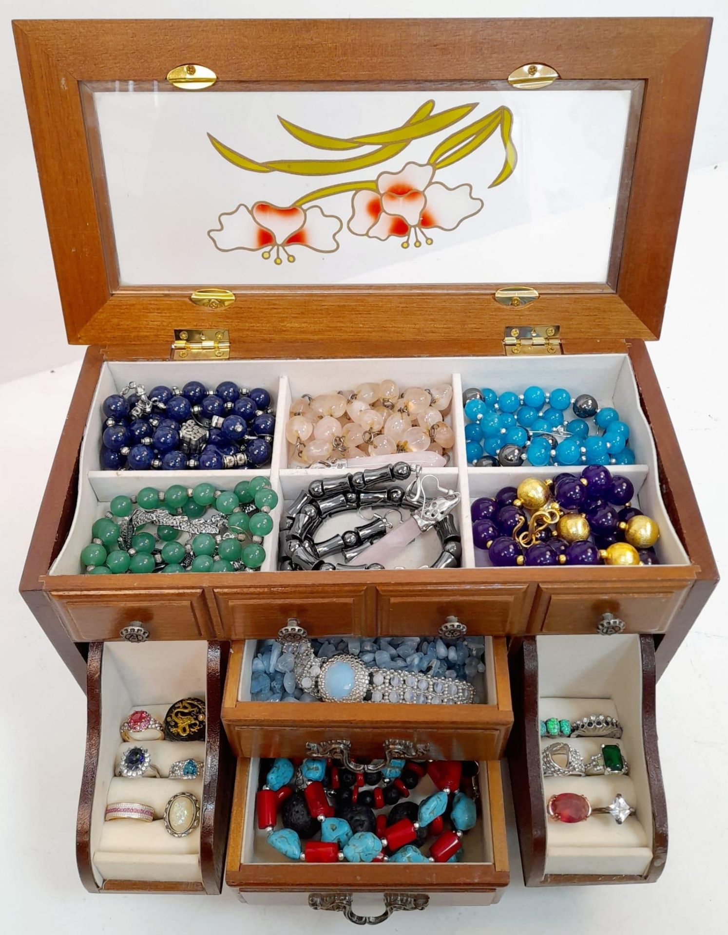 A mini jewellery box with a selection of precious and semiprecious stone sets including lapis