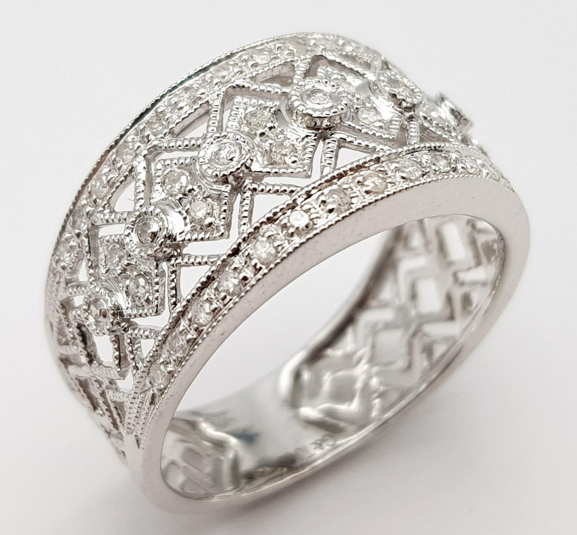 A 9K WHITE GOLD DIAMOND SET, WIDE OPEN-WORK DESIGN BAND RING. 3.3G. SIZE P.