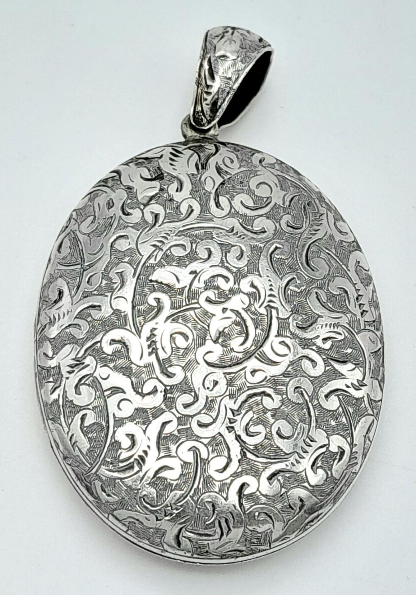 A large vintage sterling silver locket pendant with fabulous engravings. Total weight 22.2G. 6.5X3.5