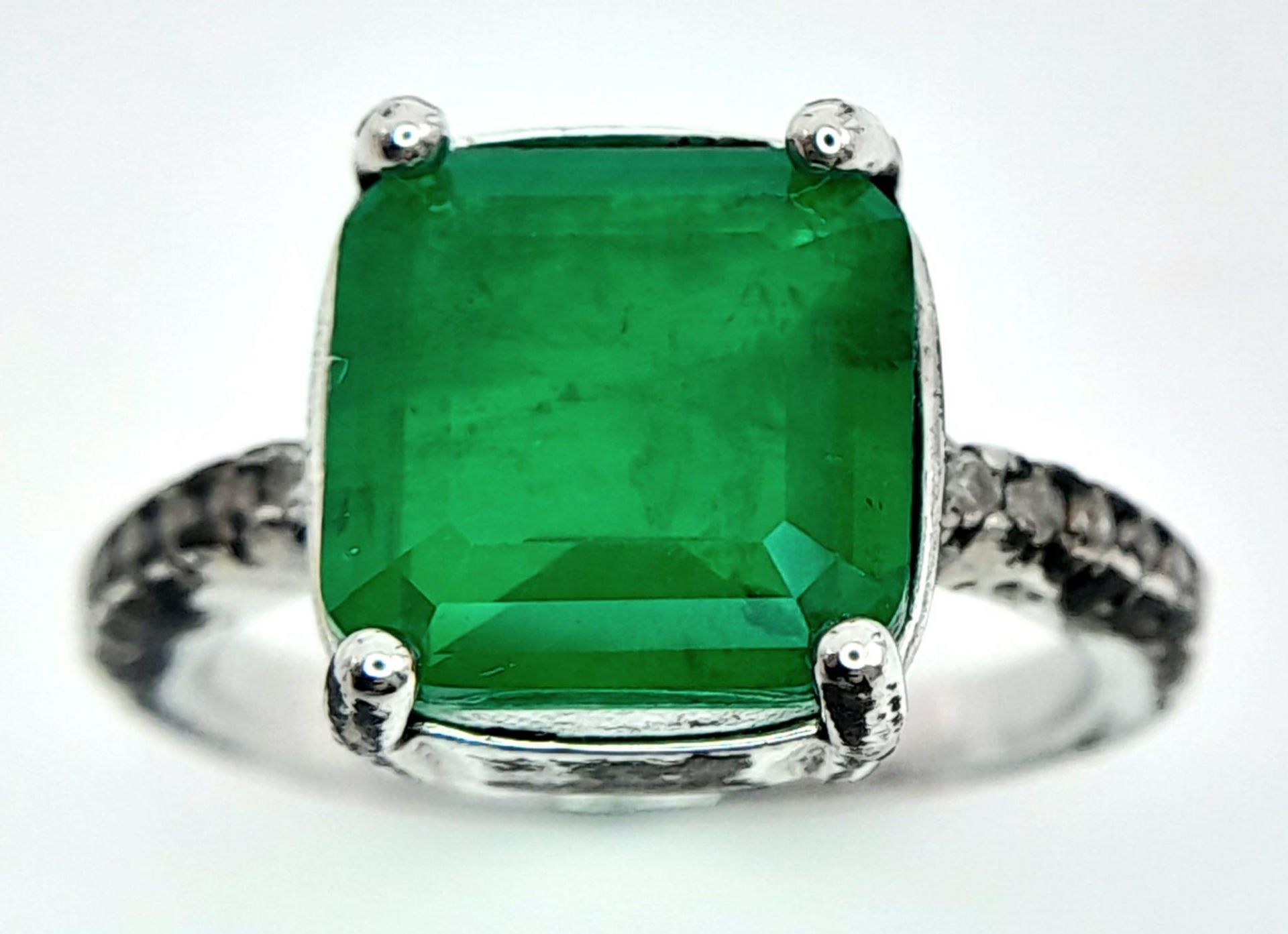 A sterling silver ring with an emerald cut synthetic emerald and cubic zirconia on the shoulders. - Image 5 of 8