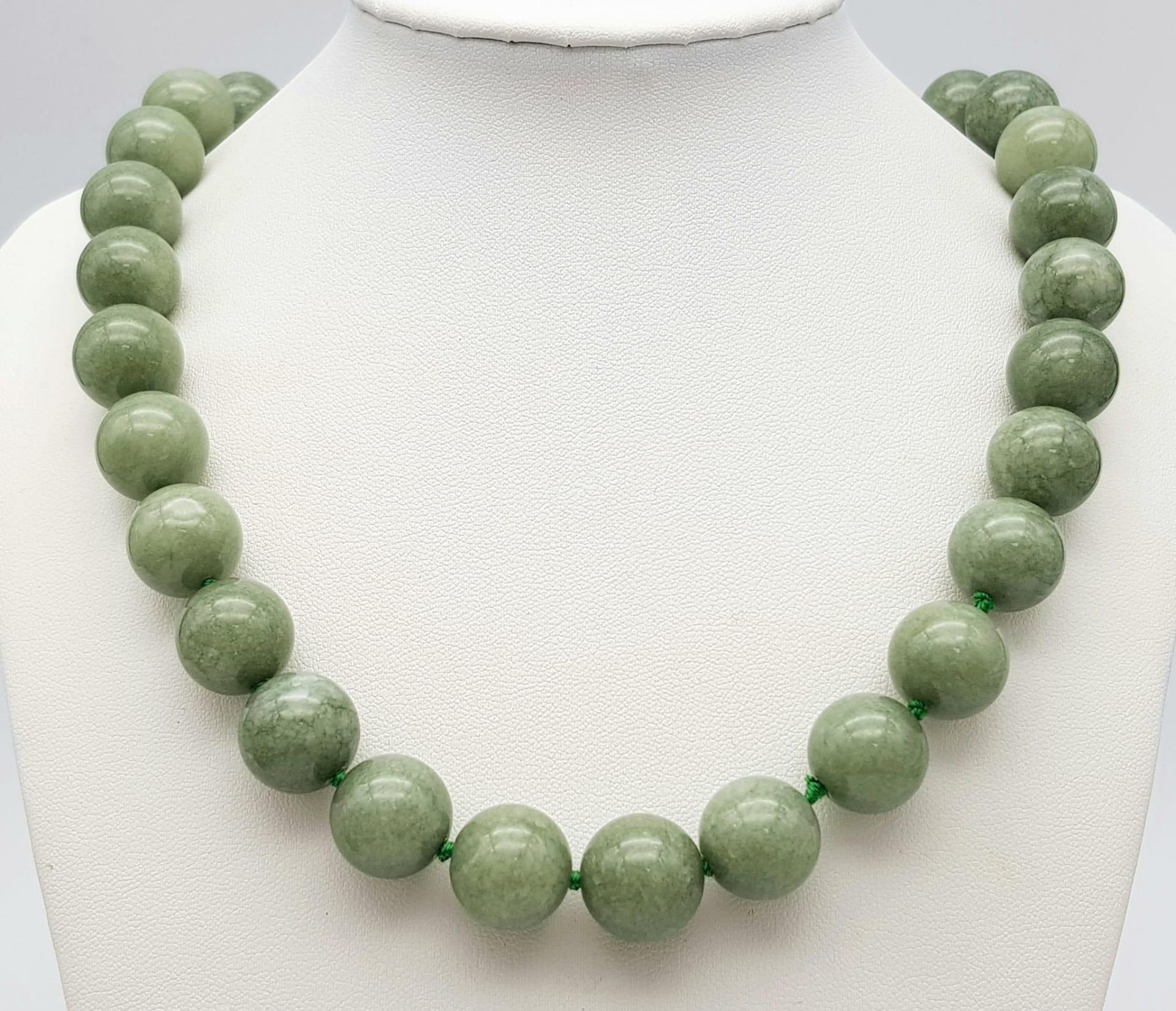 A Chinese 'Frozen Moss' Green Coloured Jade Necklace. 14mm beads. 46cm necklace length.