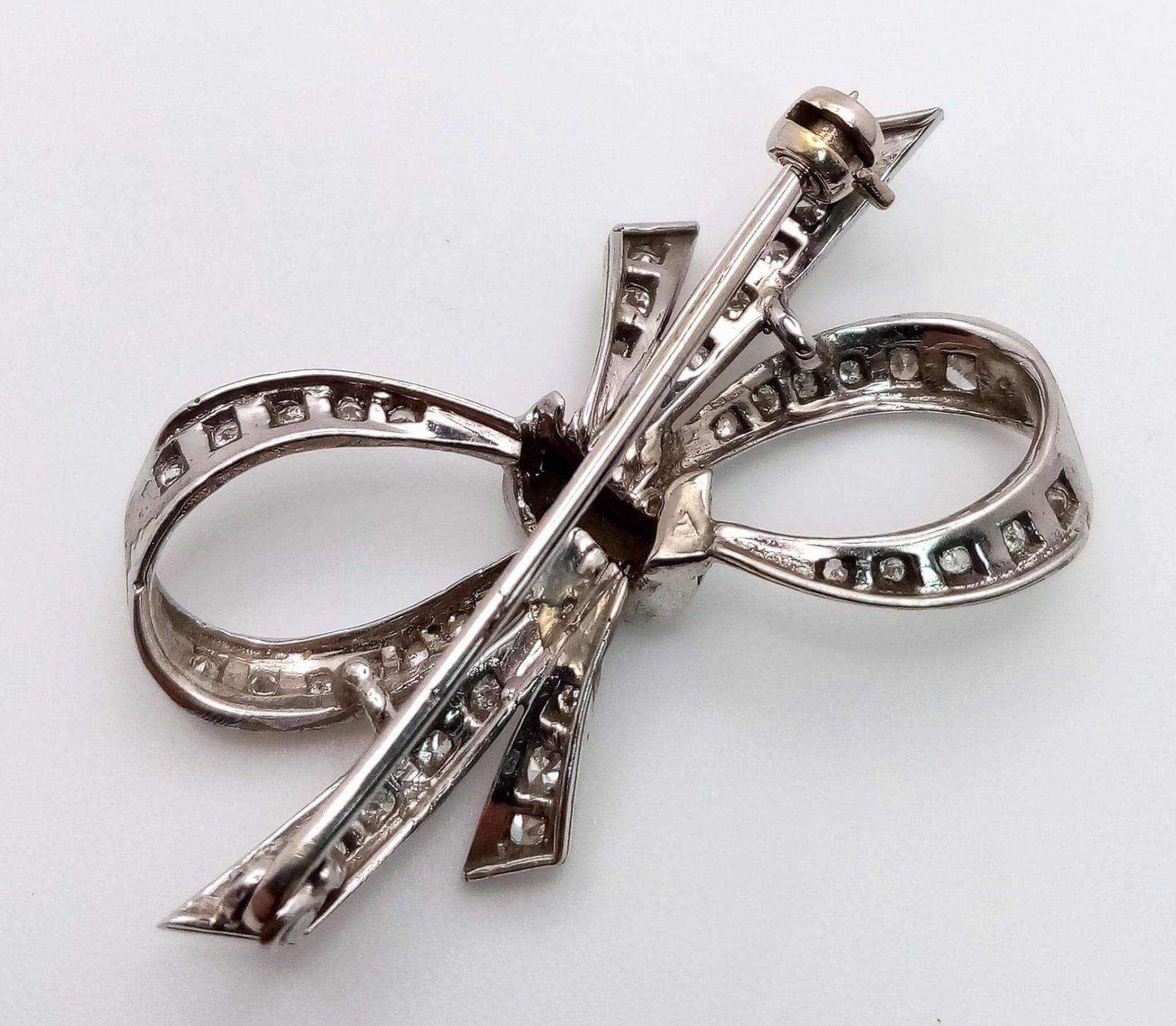 An Art Deco Style Platinum and Diamond Brooch. 1.2ctw of encrusted diamonds in a bow form. 4cm. 5.7g - Bild 2 aus 3