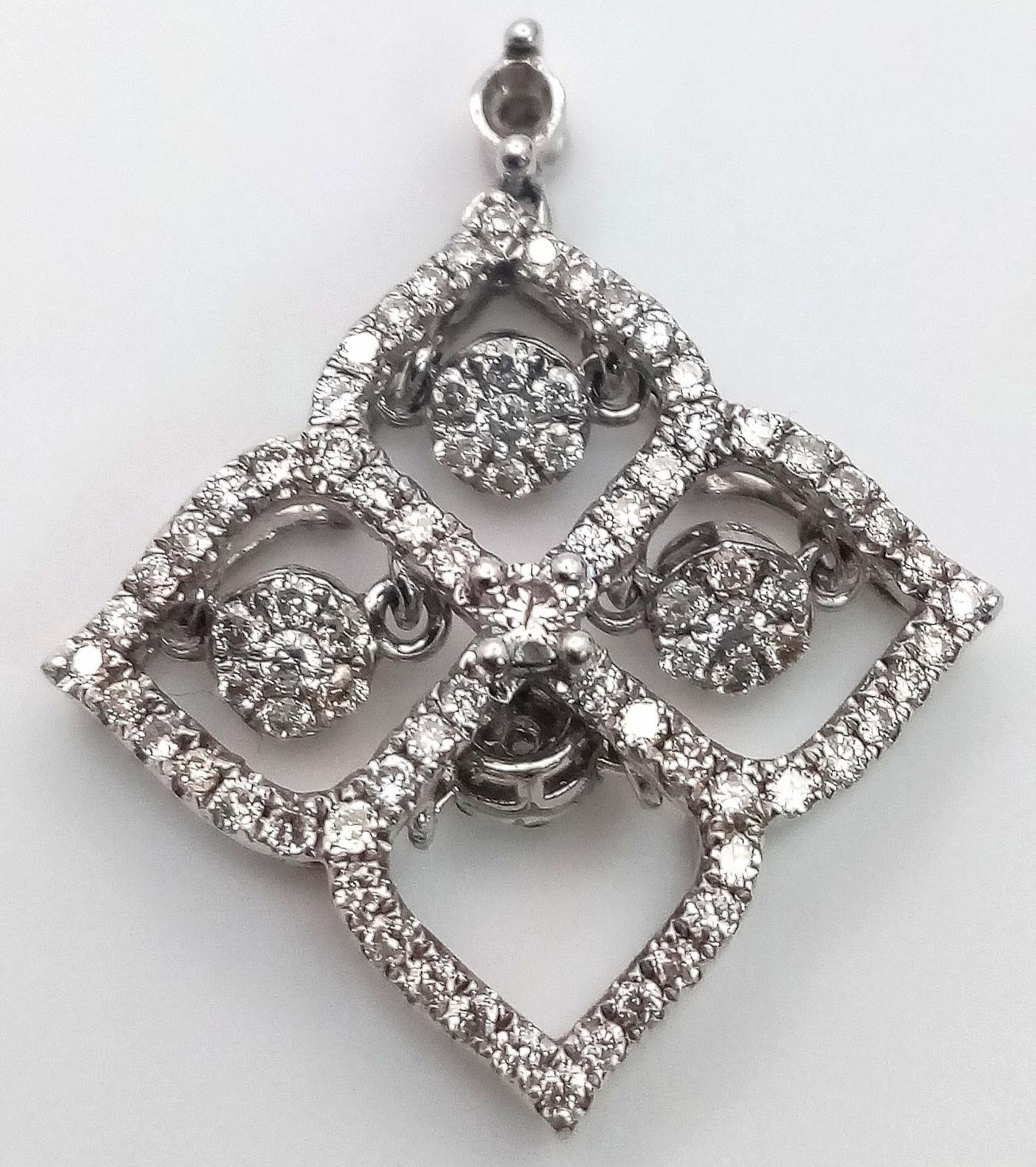 A 9 K white gold four sector pendant with diamonds and moving diamonds in each sector. Dimensions: