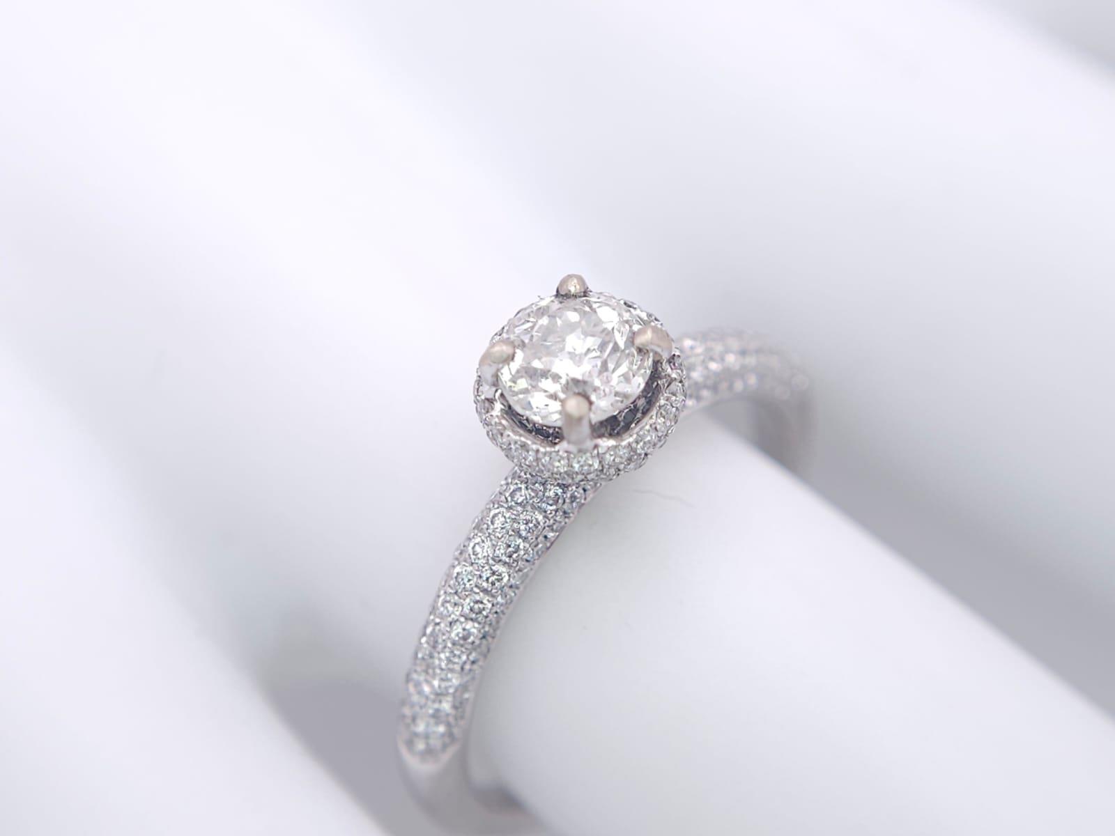 A 14K WHITE GOLD DIAMOND DIAMOND HALO RING WITH FULL SET SHOULDERS AND COLLET. 1.10CT. 2.9G. SIZE - Image 7 of 7