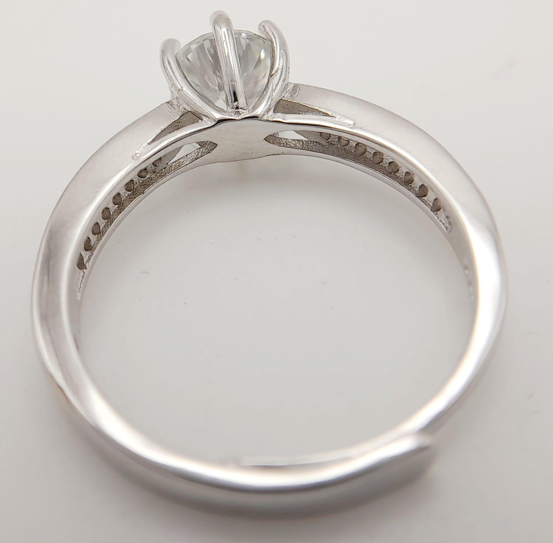 A sterling silver ring with a round cut moissanite (1 carat) and two bands of moissanites on each - Image 9 of 9