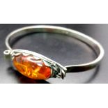 A vintage sterling silver Amber bangle. Total weight 15.7G. Widest inner length 6.7cm.