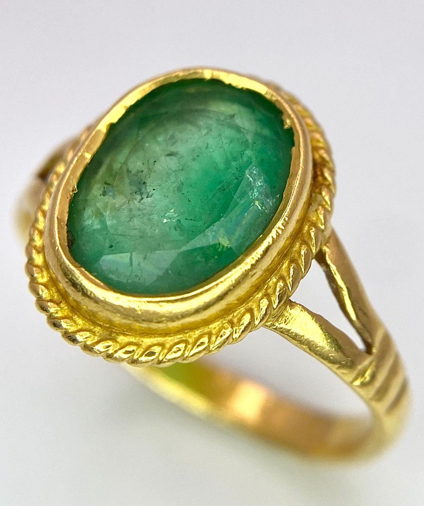 A 21K (tested) Green Emerald Ring. Central oval cut emerald. Size H. 3.15g weight.