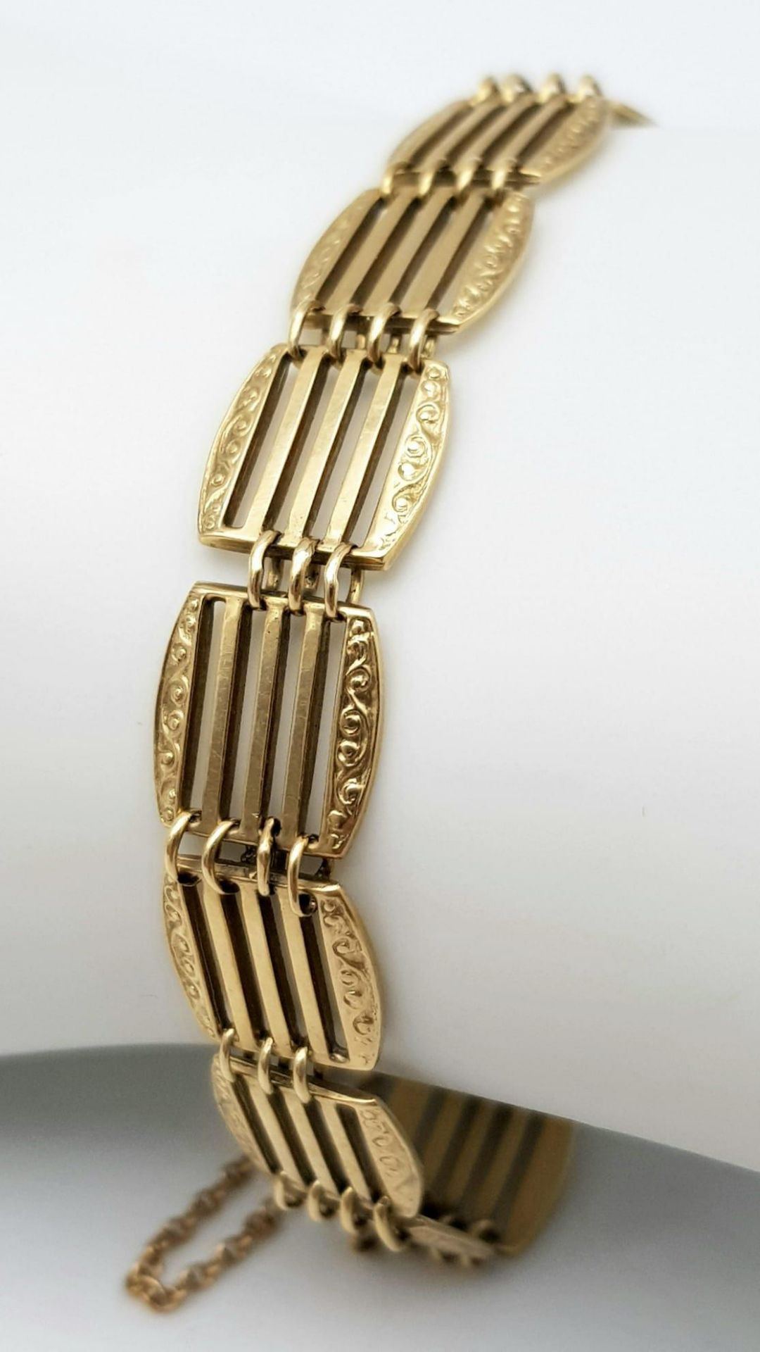 A 9K GOLD ORNATELY DECORATED GATE BRACELET . 11.1gms