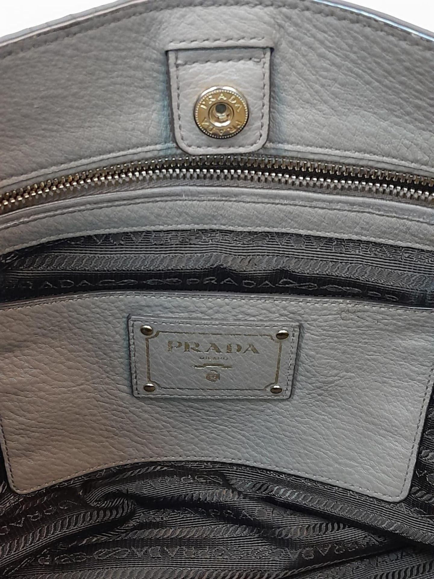 A Prada Grey Leather Shoulder Bag. Textured leather exterior with gold tone hardware. Textile and - Image 7 of 9