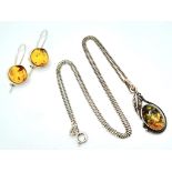 A matching set of 925 silver Amber jewellery include a pair of earrings and a pendant on silver