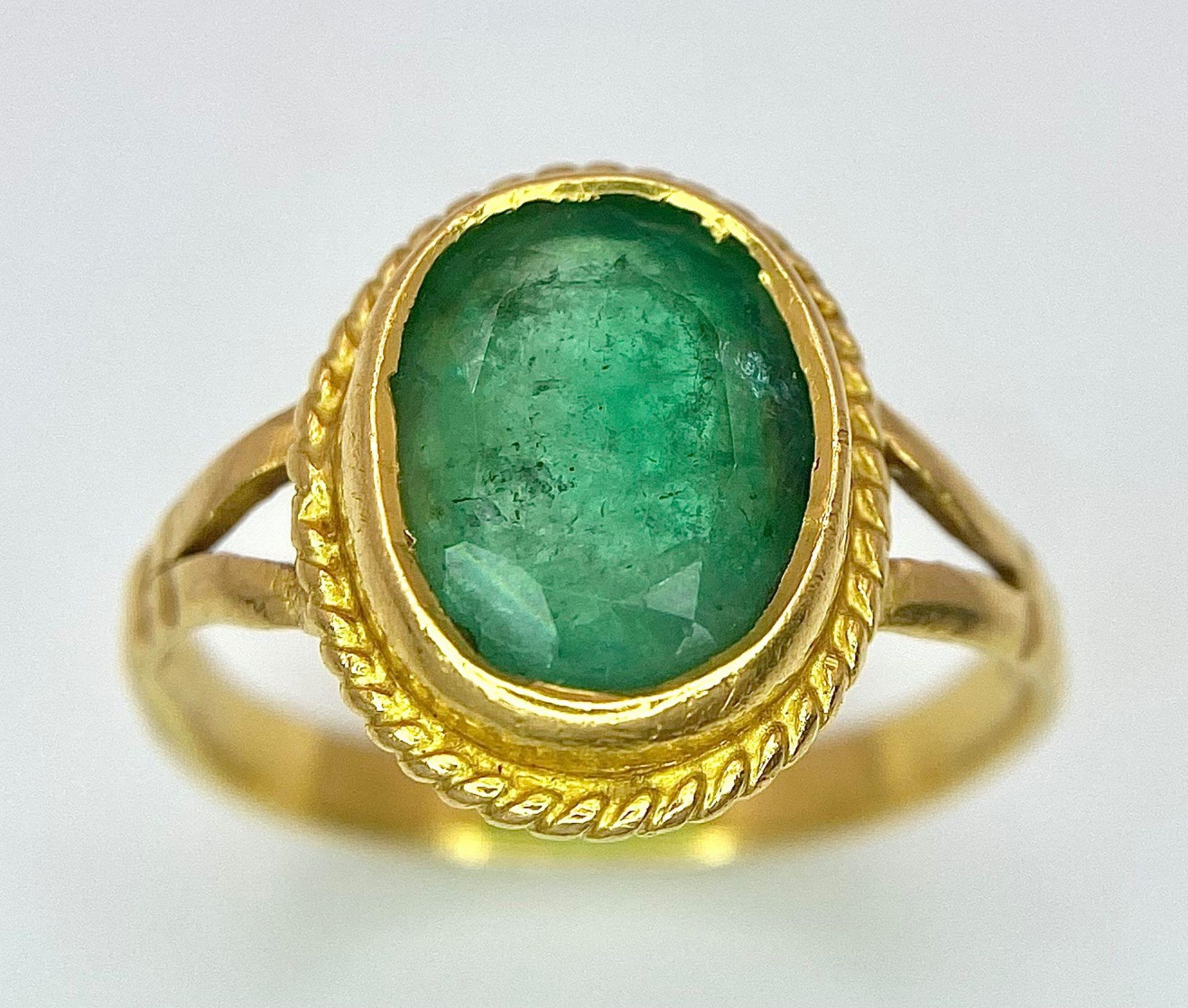 A 21K (tested) Green Emerald Ring. Central oval cut emerald. Size H. 3.15g weight. - Image 2 of 5