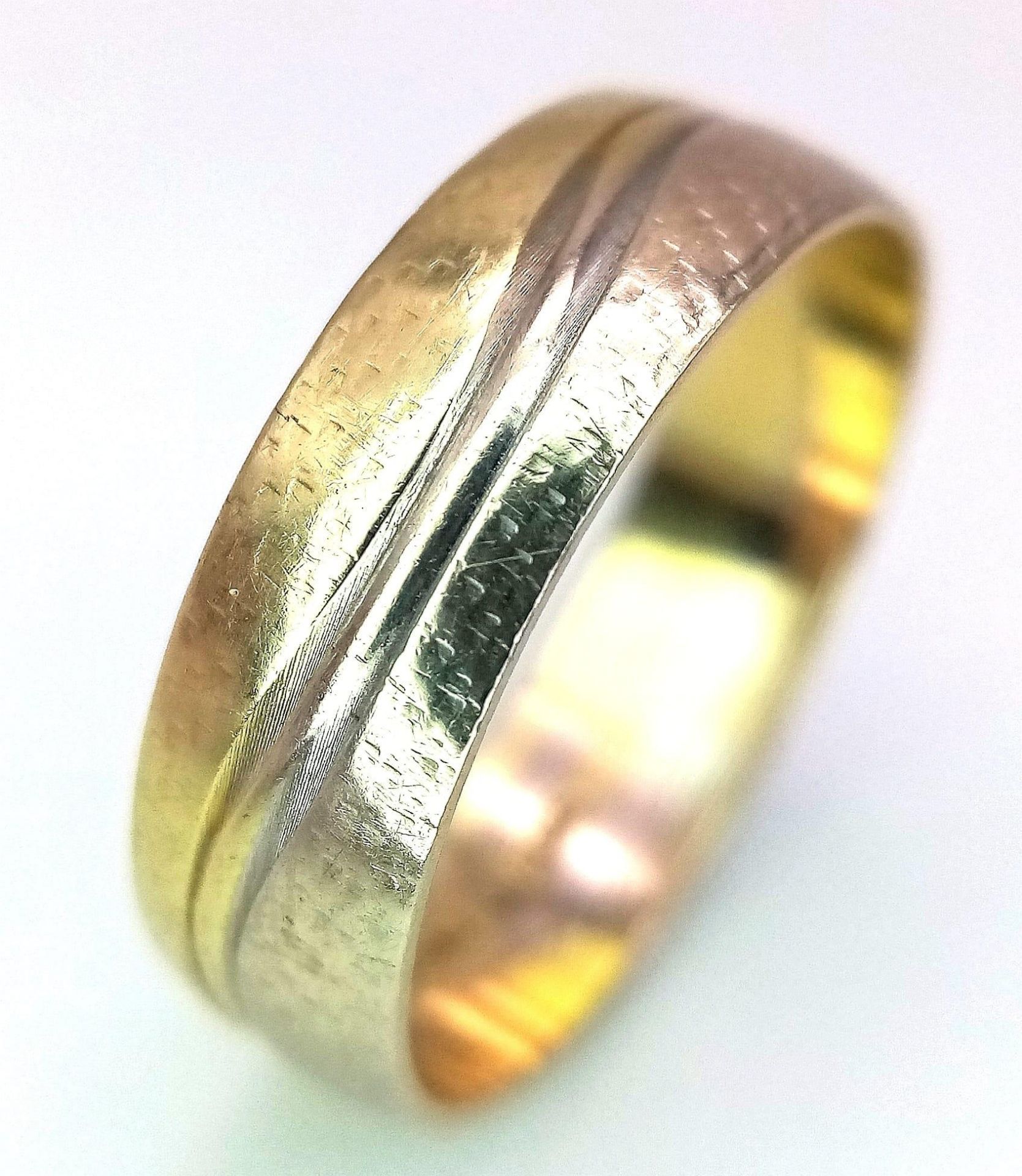 A 14K Yellow Gold Band Ring with Swirl Decoration. Size O. 2.9g weight.
