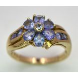 A 9K GOLD RING WITH FLORAL SHAPED AMETHYST STONES . 3.2gms size N
