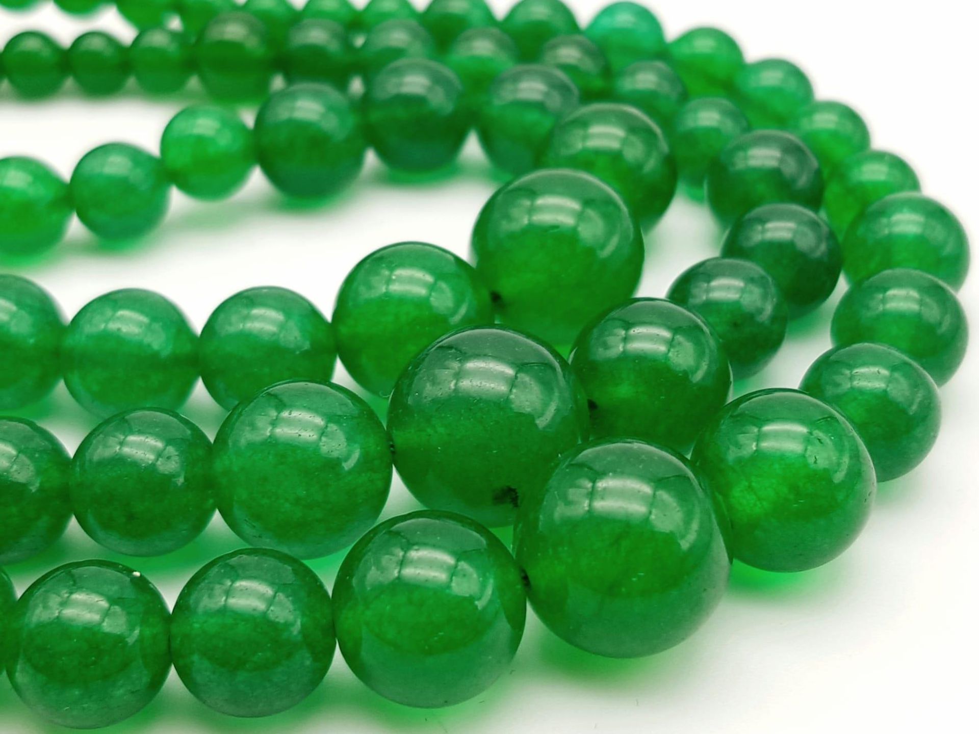 A Chinese Expansive Three Row Green Jade Necklace. A green jade bead necklace gives way to a three - Image 7 of 7