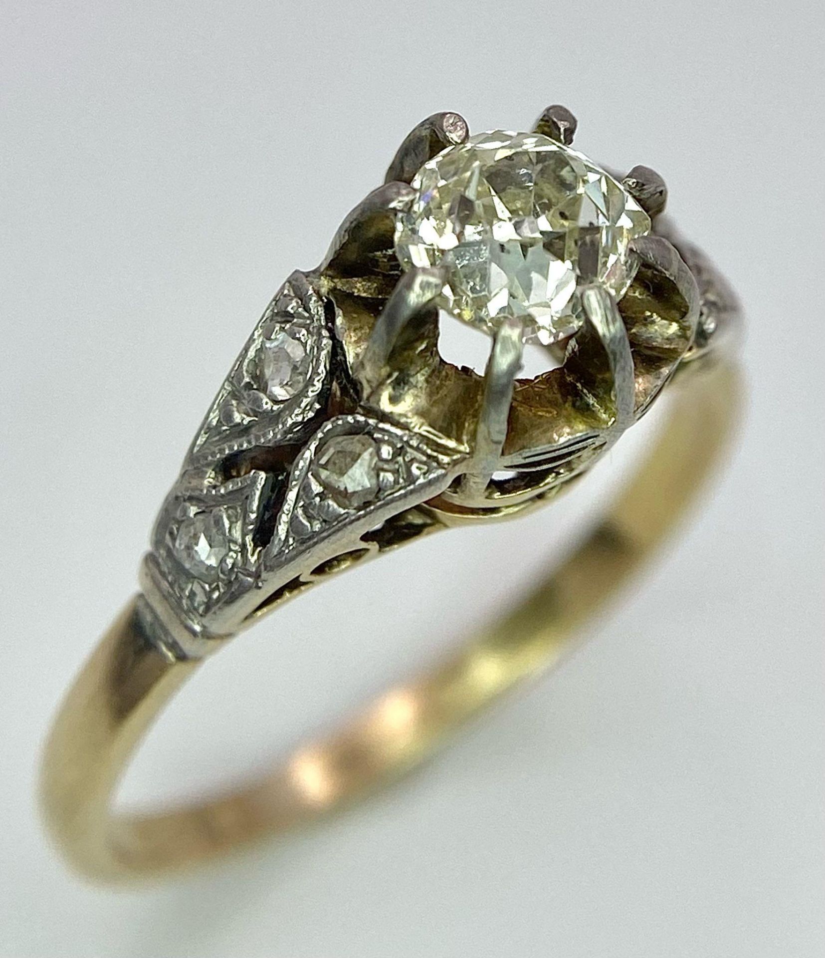 An Antique 18K Gold, Platinum and Diamond Ring. Central 0.75ct central stone with diamond accents on