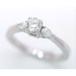 AN 18K WHITE GOLD DIAMOND RING WITH PEAR SHAPED DIAMOND ACCENTS ON SHOULDERS. 0.40CTW OF PEAR SHAPED