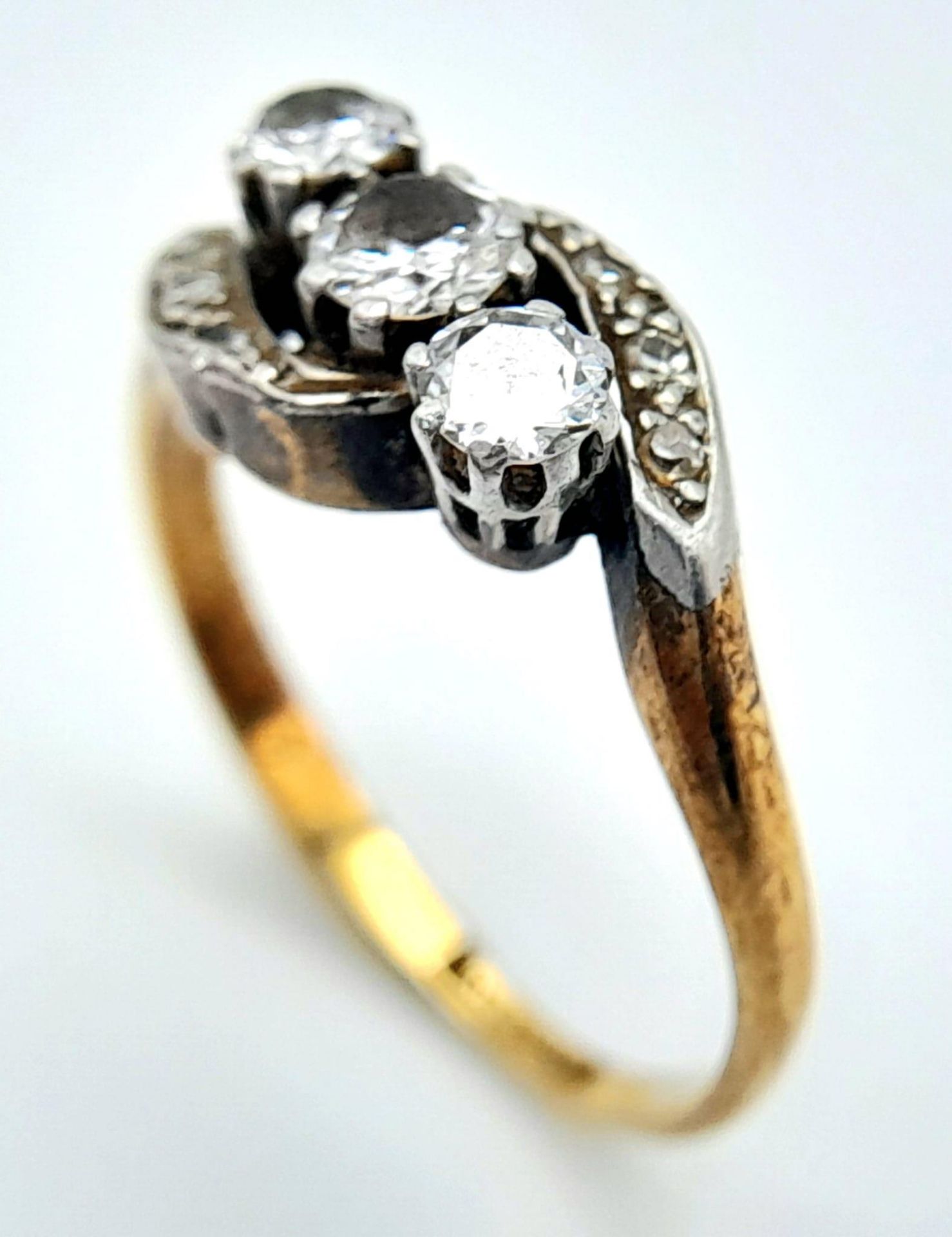 AN ANTIQUE 18K GOLD CROSSOVER STYLE RING WITH A TRILOGY OF DIAMONDS SET IN PLATINUM . 3.6gms size - Image 4 of 7