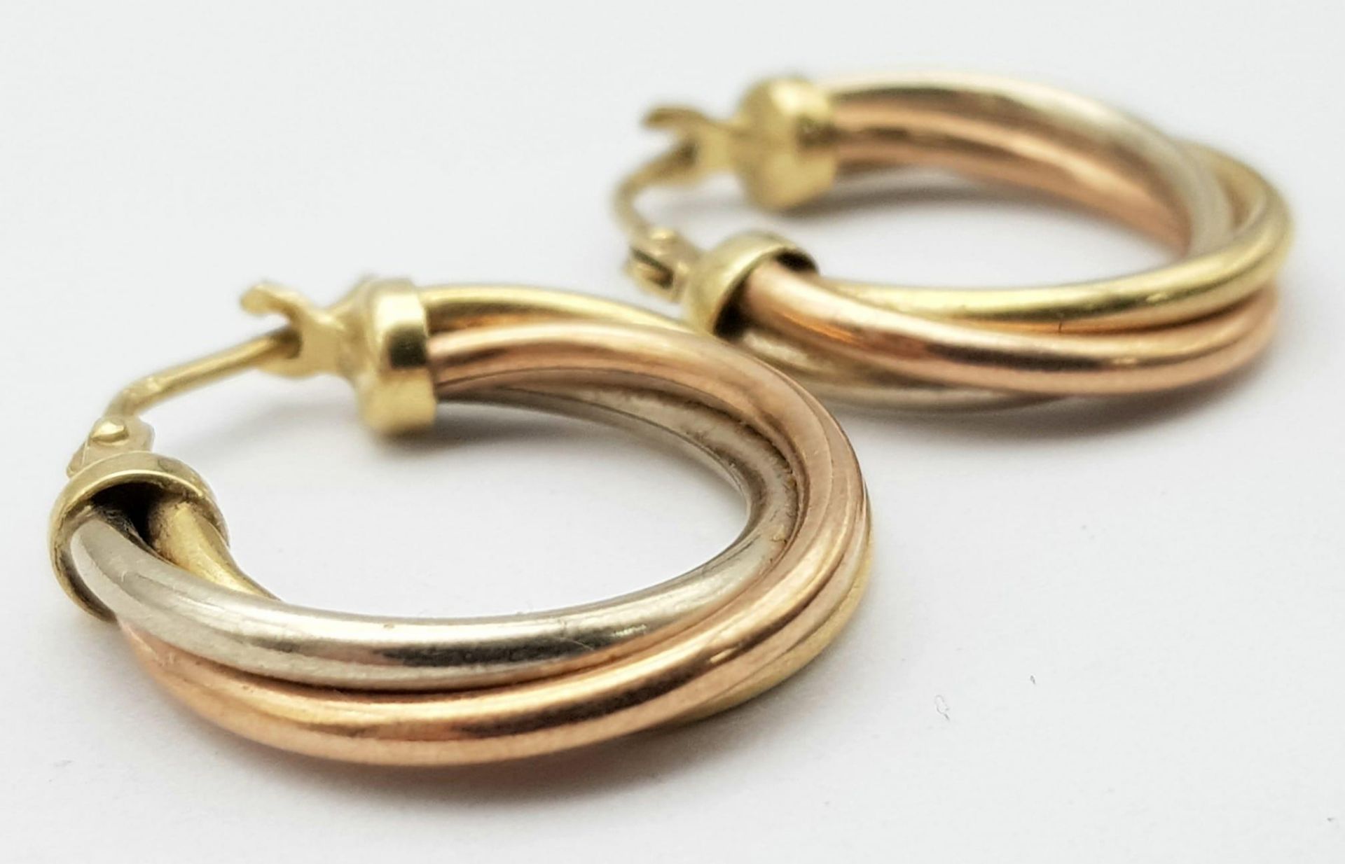 A 9 K tri-coloured gold pair of hoop earrings, length: 21 mm, weight: 2.5 g. - Bild 2 aus 4