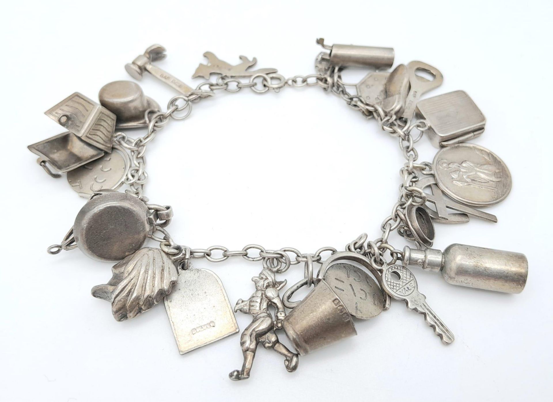 A Sterling Silver Charm Bracelet with 23 Charms. 18cm length, 48.5g total weight. Ref: SC 7088