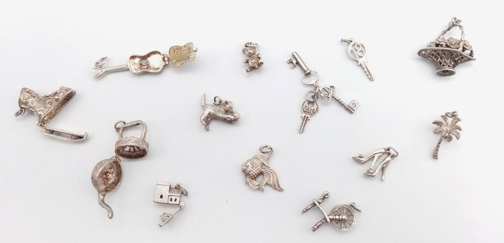 A collection of vintage silver charms/pendants such as a cat, castle, etc. Total weight 43.4G.