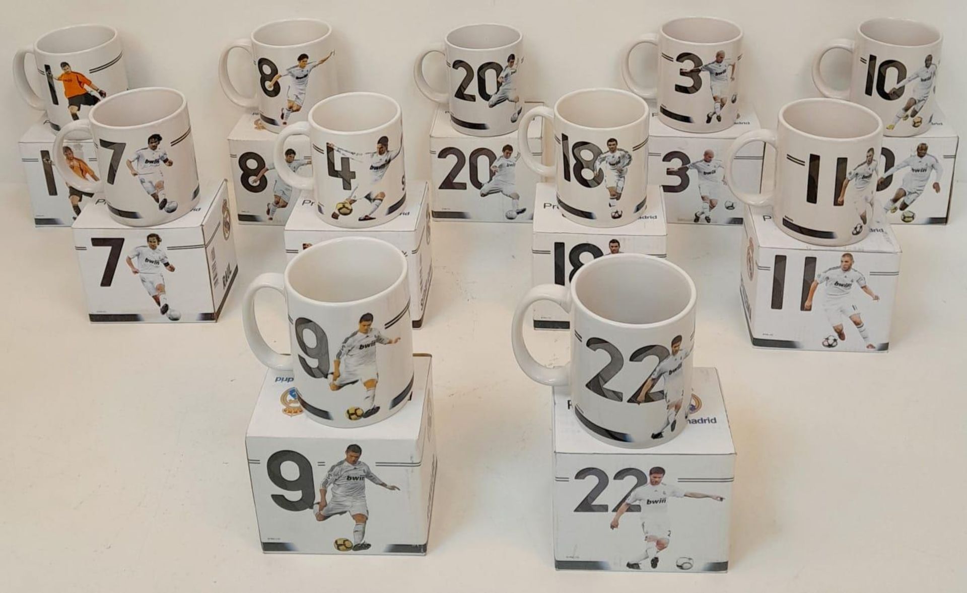 A Collection of Eleven Real Madrid Mugs - Each decorated with a different player. As new, in