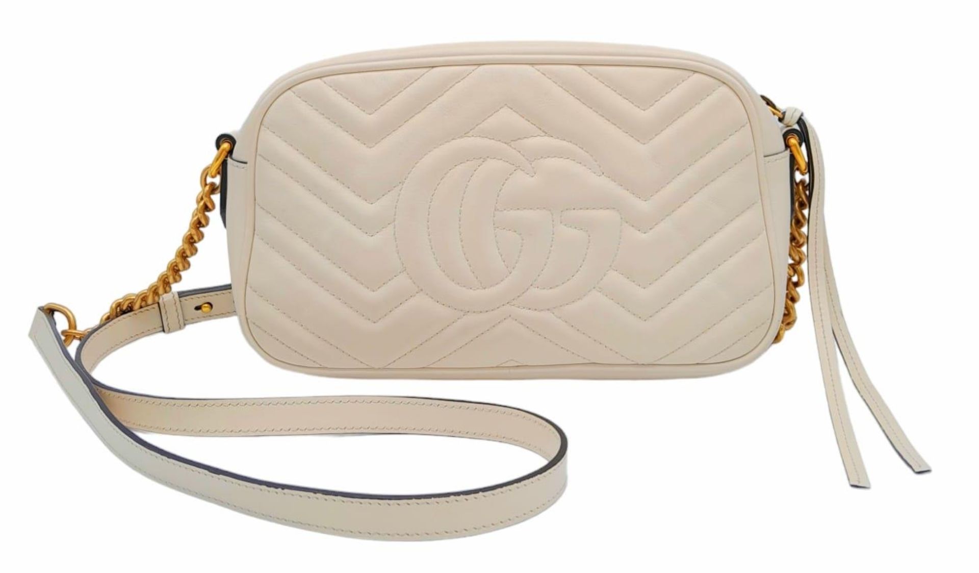 A Gucci Ivory GG Marmont Cross Body Bag. Quilted leather exterior with gold-toned hardware, chain