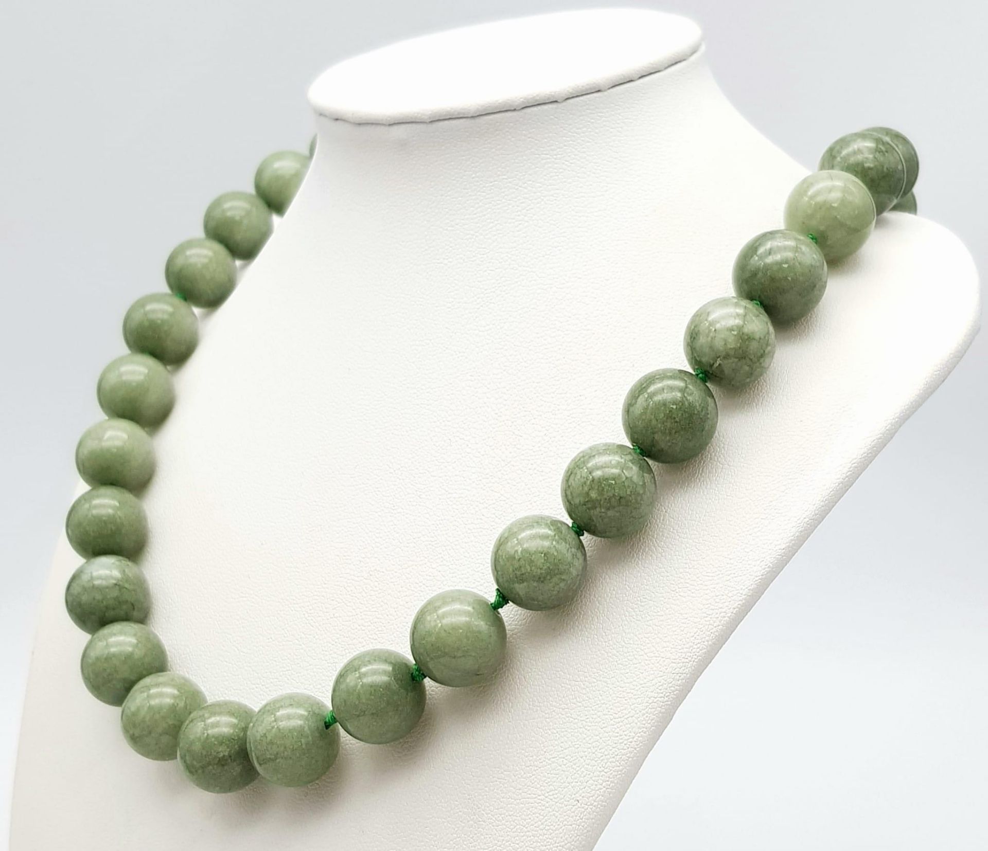 A Chinese 'Frozen Moss' Green Coloured Jade Necklace. 14mm beads. 46cm necklace length. - Image 2 of 3