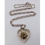 A vintage sterling silver floral heart pendant on 925 silver figaro chain. Total weight 6.5G.