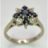 An 18 K white gold ring with a cluster of diamonds and dark blue sapphires. Size: M, weight: 4 g.