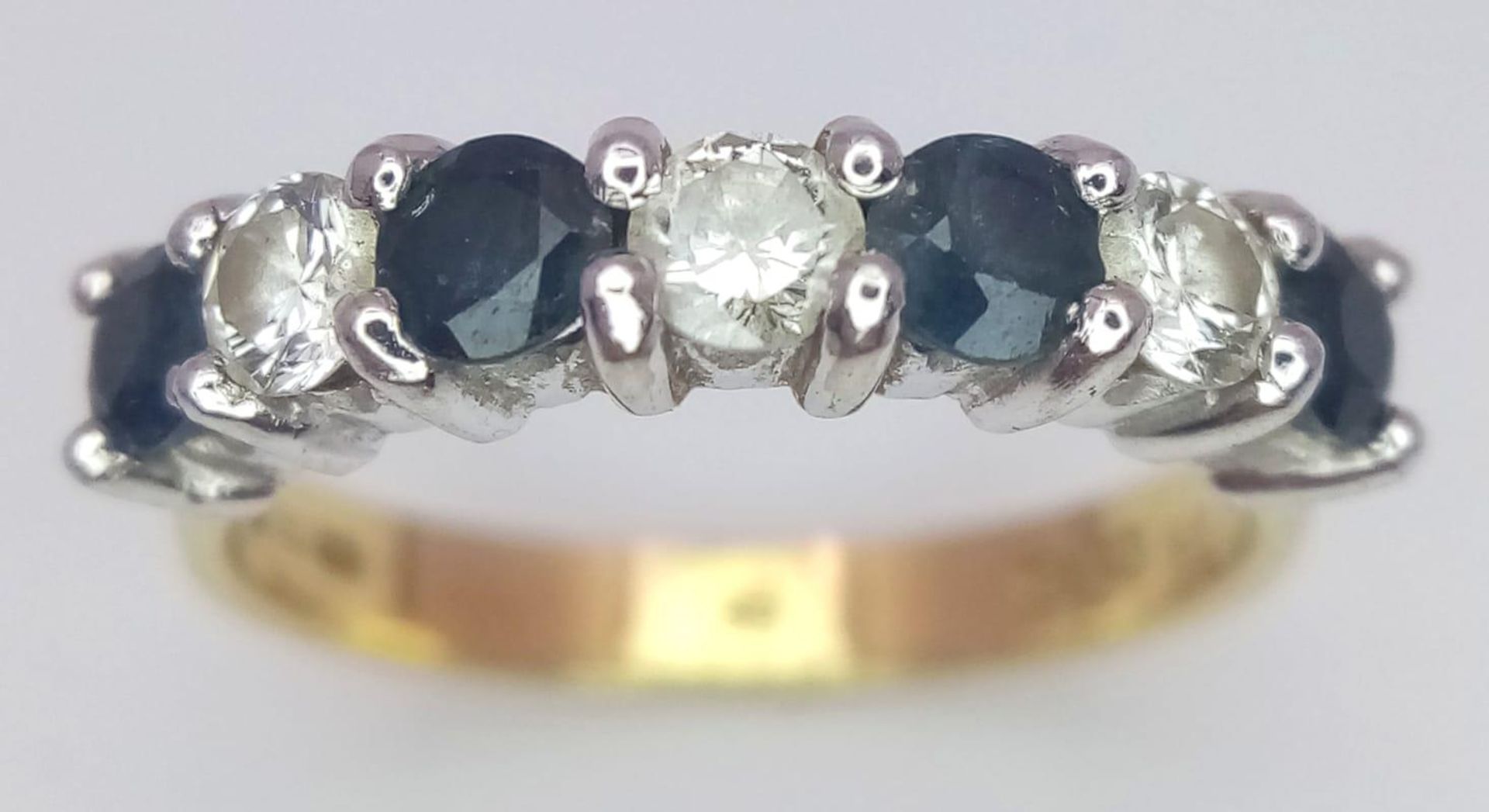An 18 K yellow gold ring with a band of alternating round cut diamonds and blue sapphires. Size: - Image 2 of 4