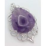 A 9 K white gold pendant with a large pear shaped amethyst cabochon (80.36 carats) set on an ART