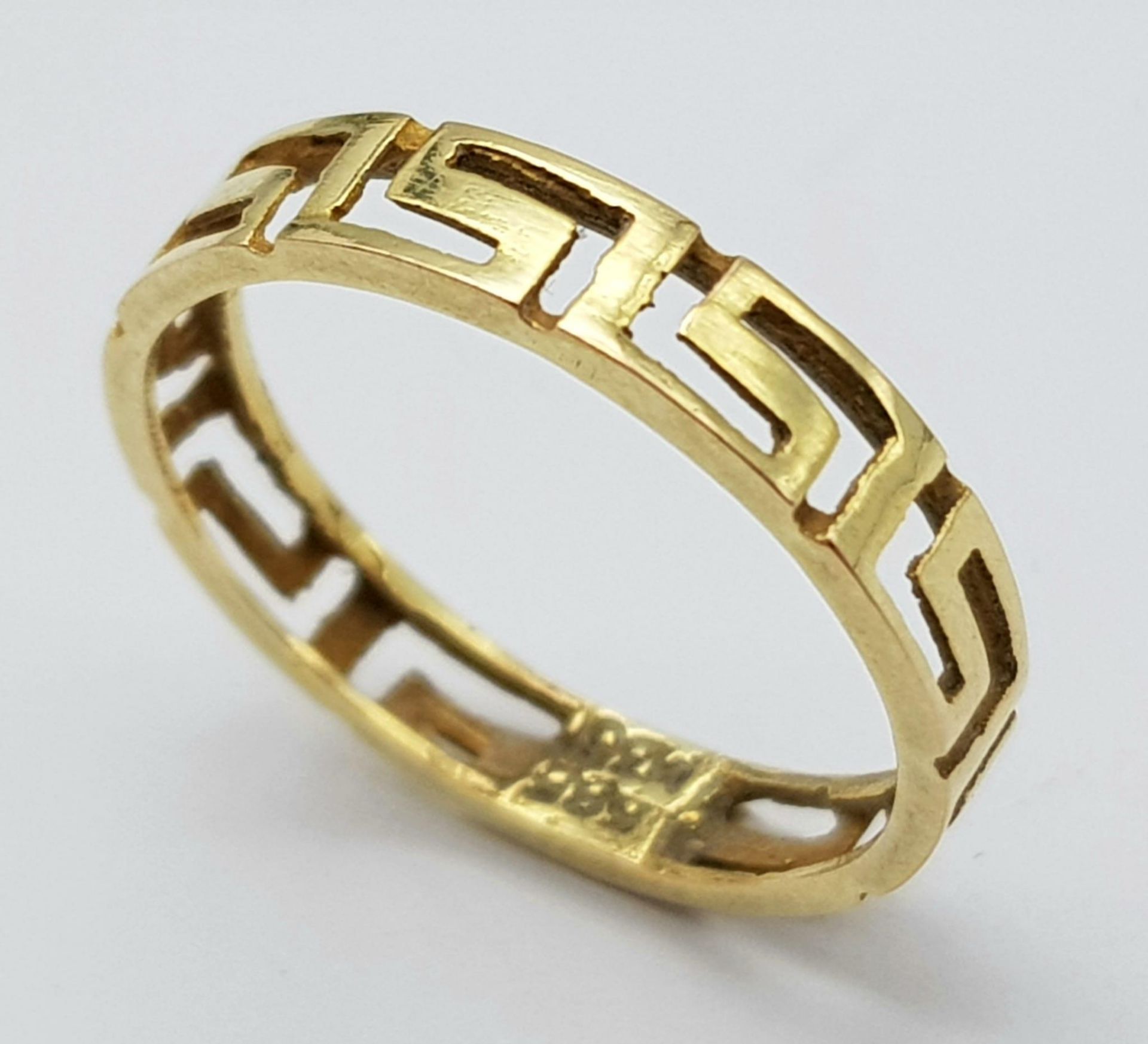 A nice 9 K yellow gold band ring with the Greek key design all around it. Size: K, weight: 1 g.