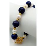 A Lapis Lazuli and Cultured Pearl Bracelet. Gilded spacers and magnetic glitterball clasp.