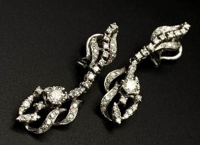 A Pair of Art Deco Style 18K White Gold and Diamond Drop Earrings. An array of round and brilliant