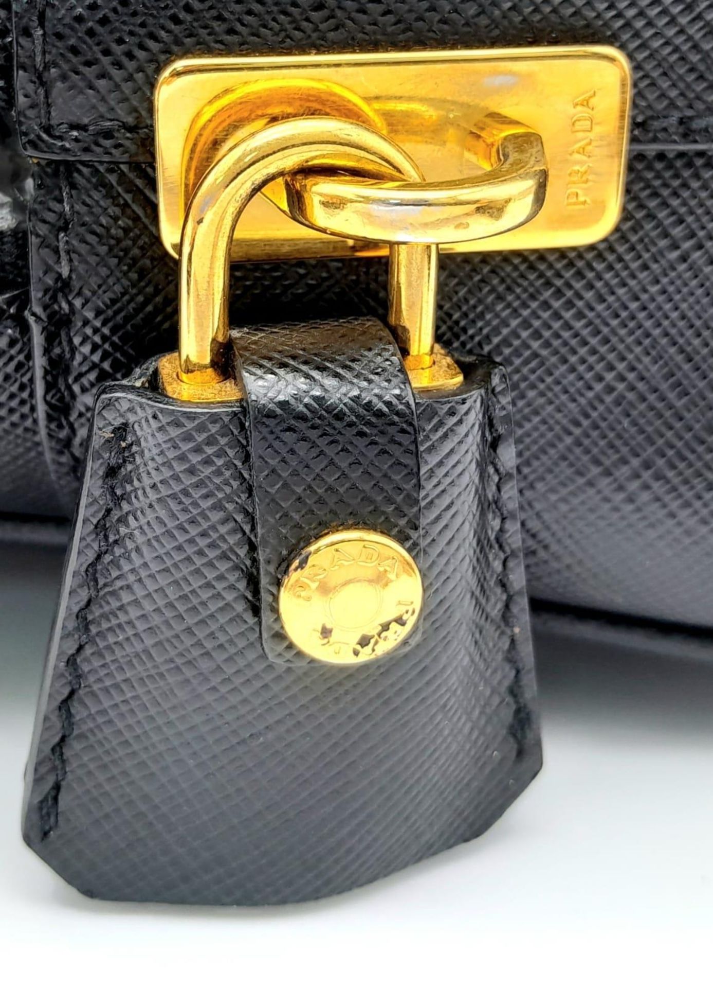 A Prada Black Bauletto Handbag. Saffiano leather exterior with gold-toned hardware, padlock, 2 - Bild 8 aus 11