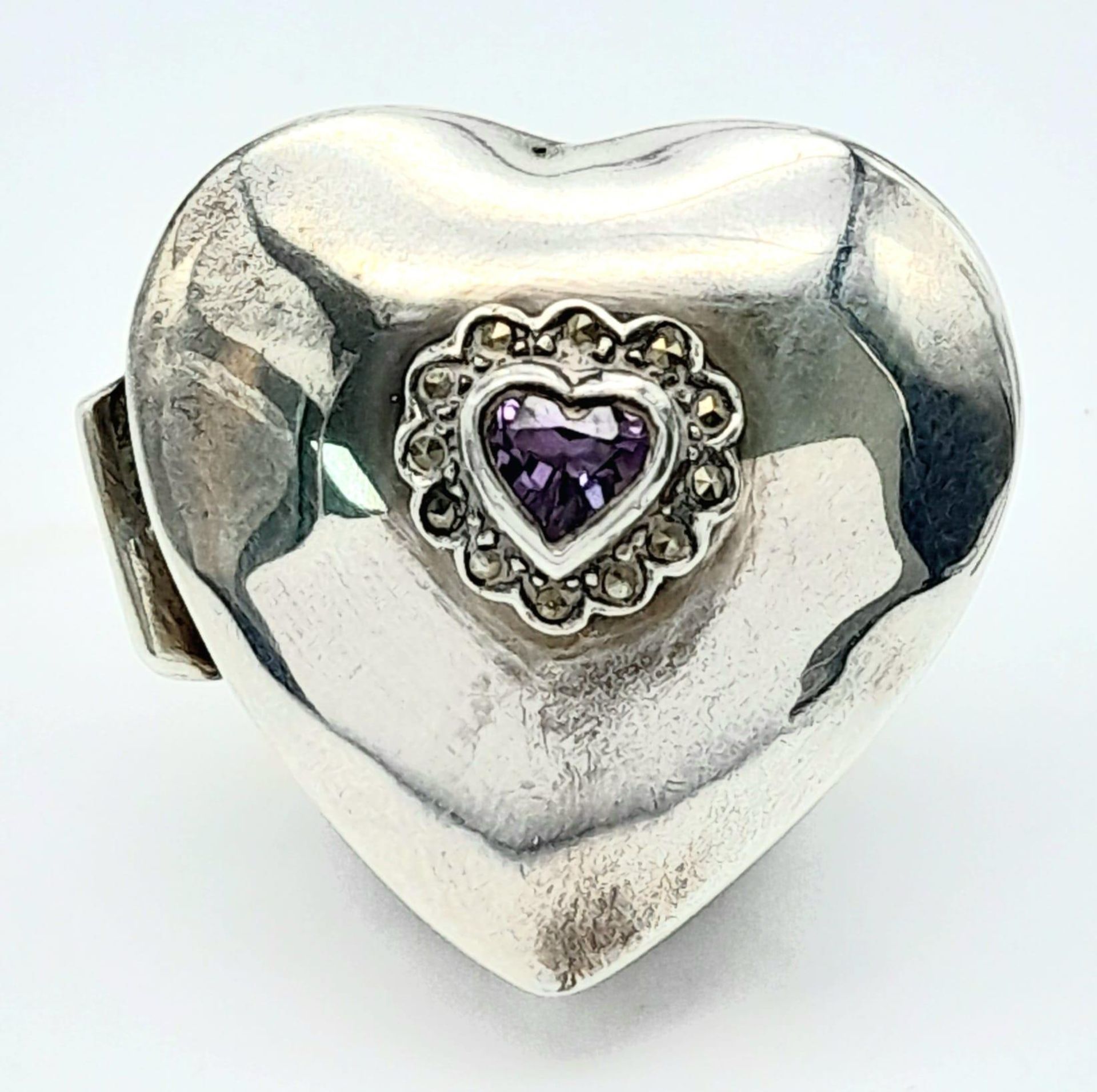 A Vintage Sterling Silver Heart Shaped Pill Box with Amethyst Decoration. Hallmarks at rear. 3.5 x