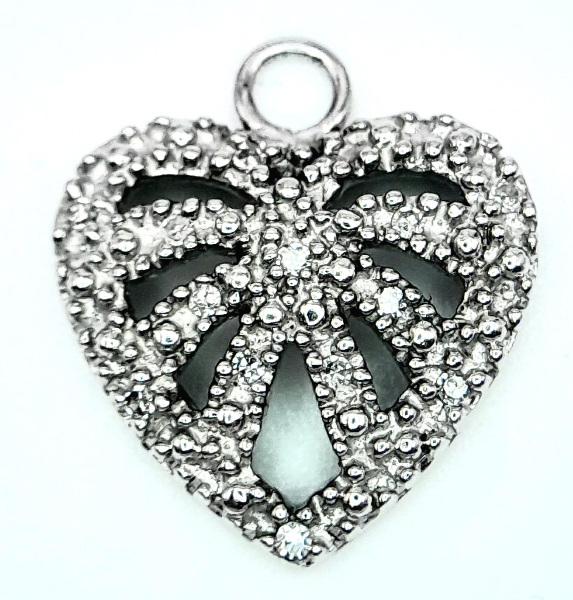 A 9K White Gold Diamond Set Heart Pendant/Charm. 1.7cm length, 1.3g total weight. Ref: 8413