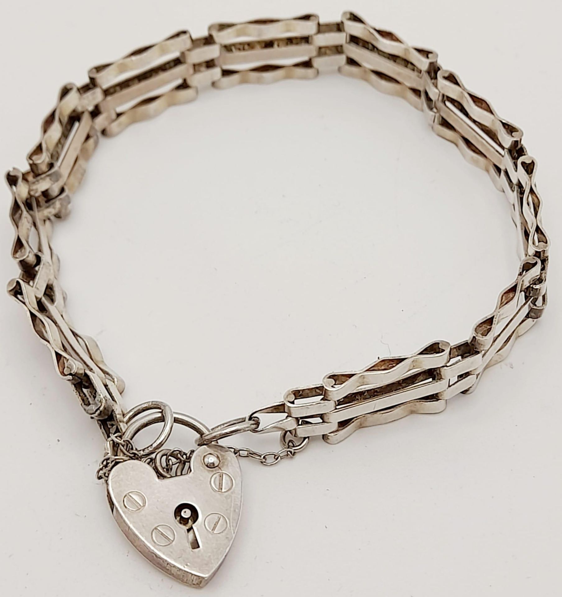 A vintage sterling silver bar gate link bracelet with heart padlock. Full hallmarks London, 1979.