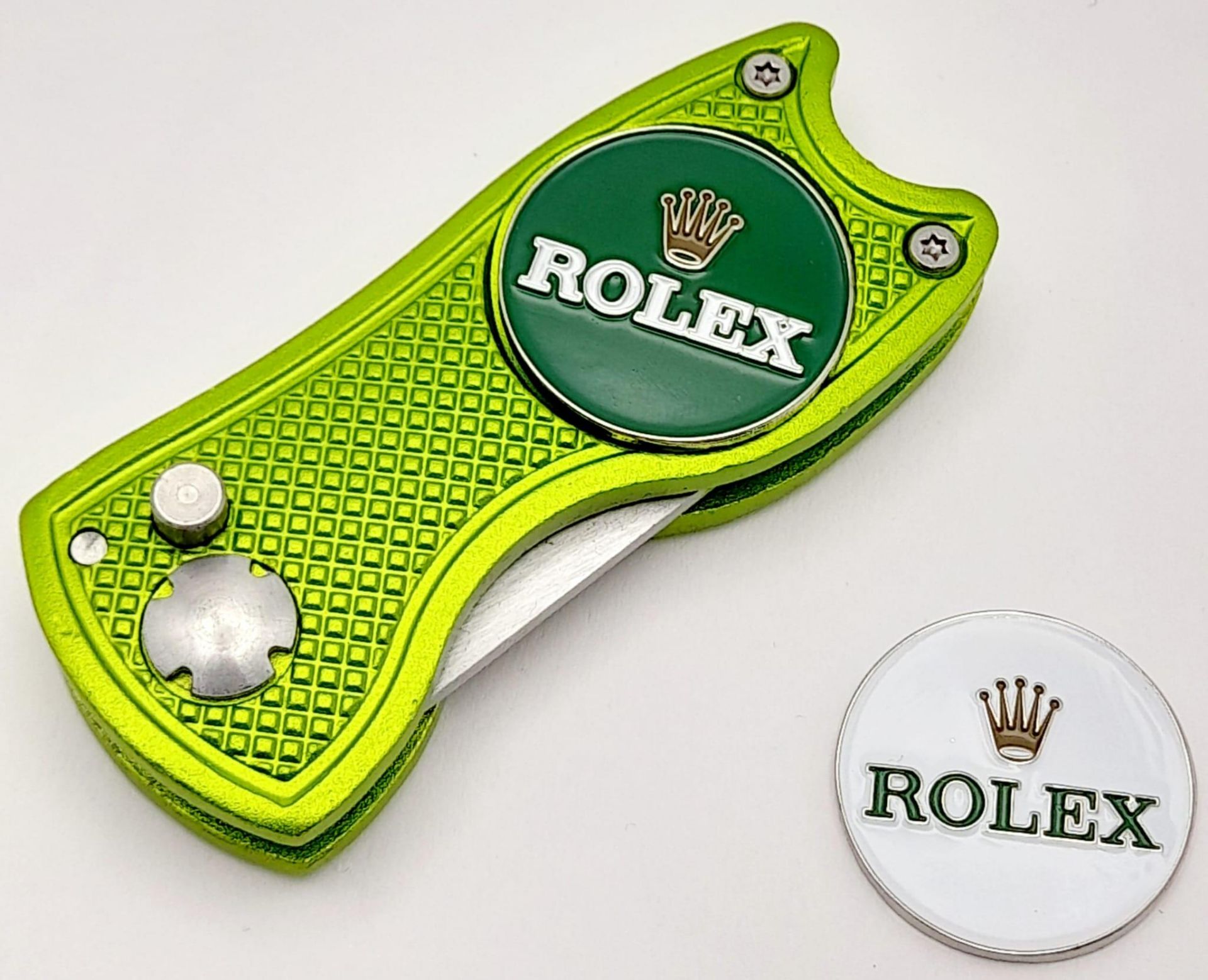 A Rolex Branded Golf Putting Green Divot Repair Tool with Removable Rolex Branded Ball Markers.