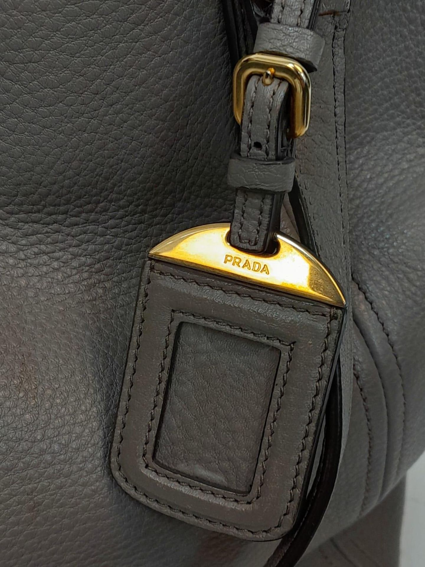 A Prada Grey Leather Shoulder Bag. Textured leather exterior with gold tone hardware. Textile and - Image 6 of 9