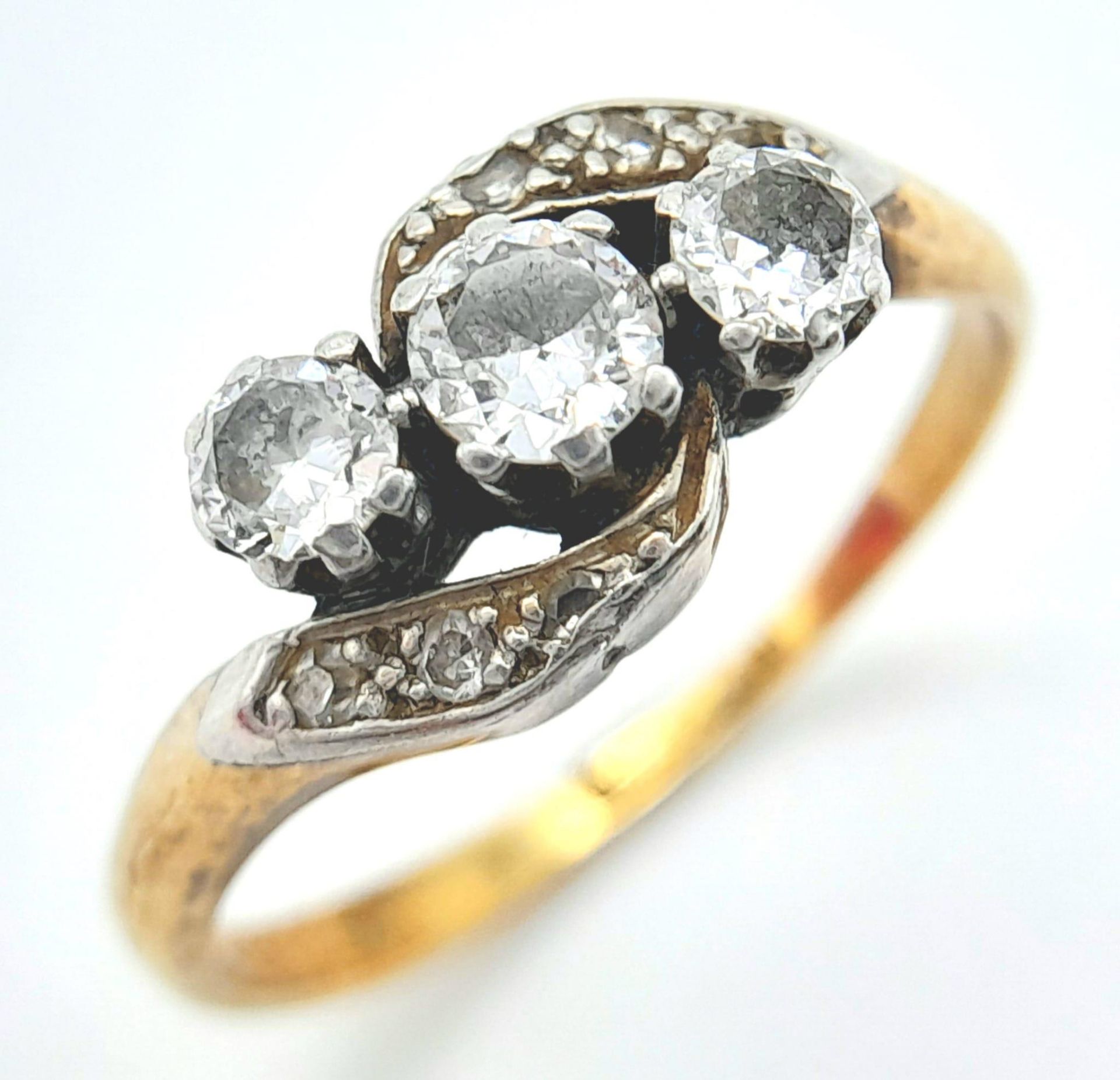 AN ANTIQUE 18K GOLD CROSSOVER STYLE RING WITH A TRILOGY OF DIAMONDS SET IN PLATINUM . 3.6gms size - Image 5 of 7