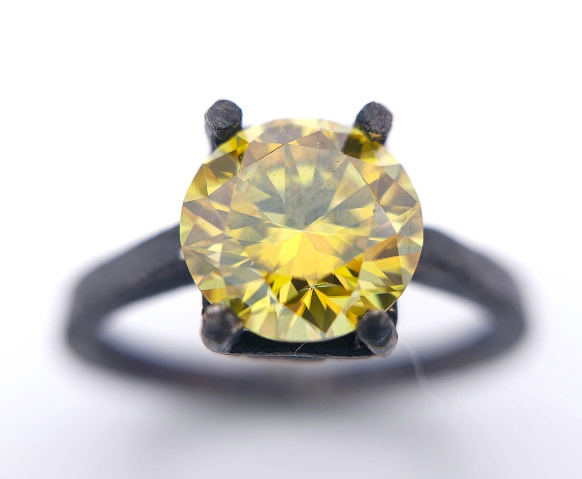 A sterling silver, with a black patina, solitaire ring with a round cut, yellow moissanite (2