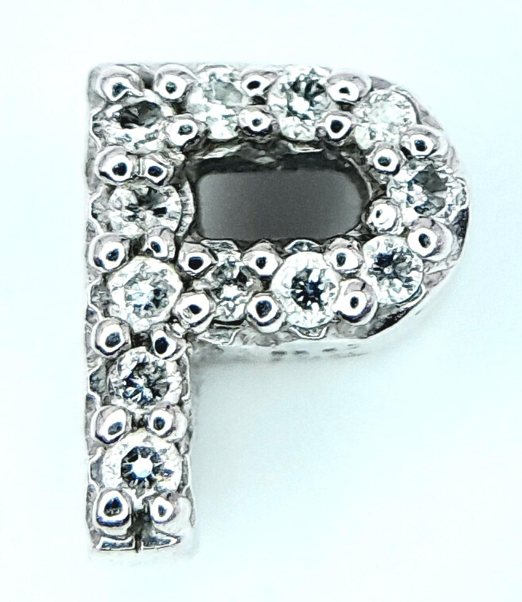 AN 18K WHITE GOLD DIAMOND SET INITIAL P PENDANT. 0.6G. 6MM.