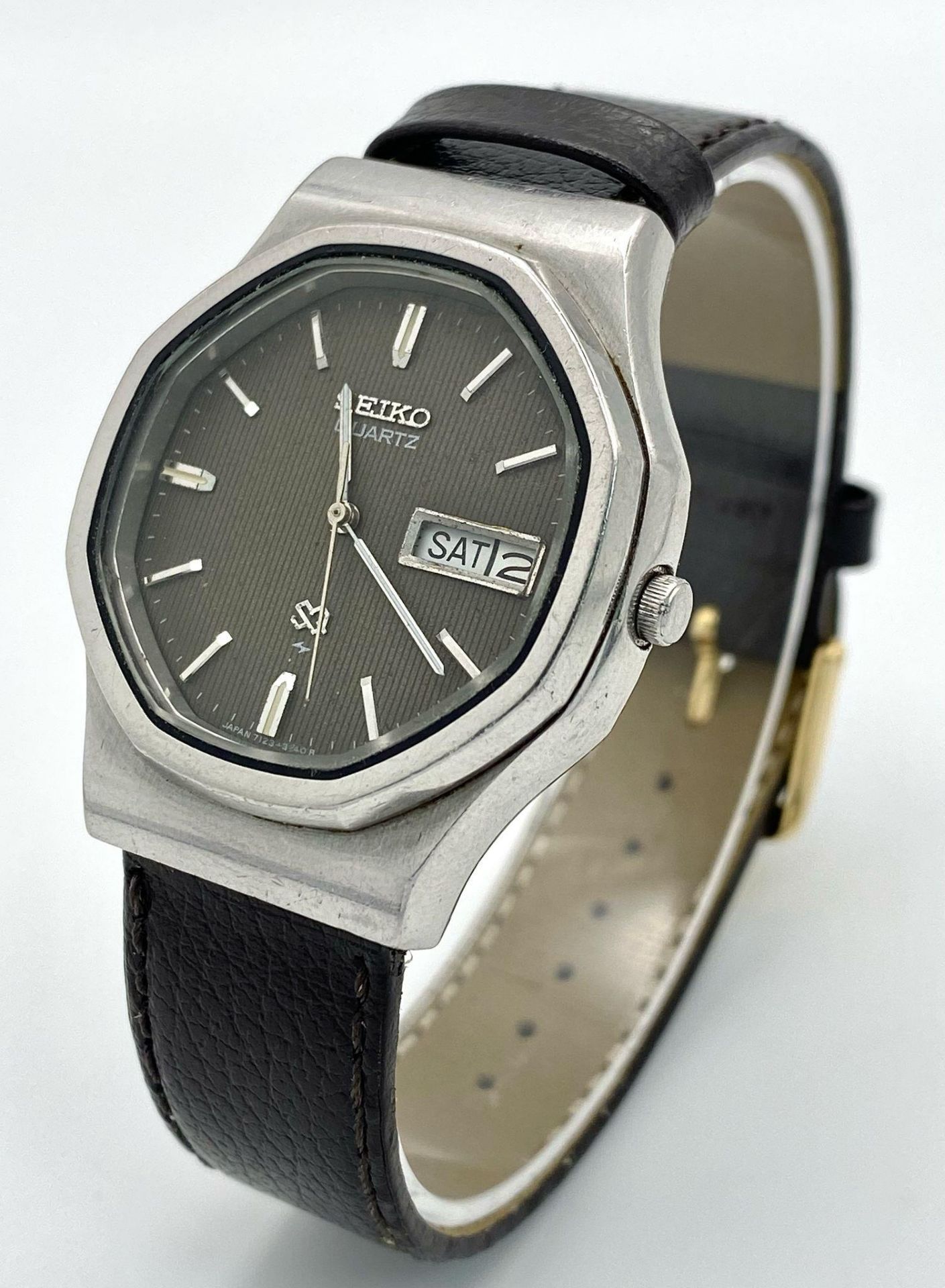 A Vintage Seiko Quartz Watch. Black leather strap. Octagonal case - 36mm. Grey dial with day/date