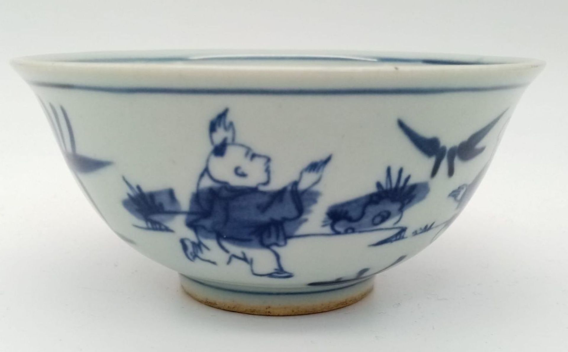 A Chinese blue and white hand painted bowl decorated with children playing with birds. White - Image 3 of 6