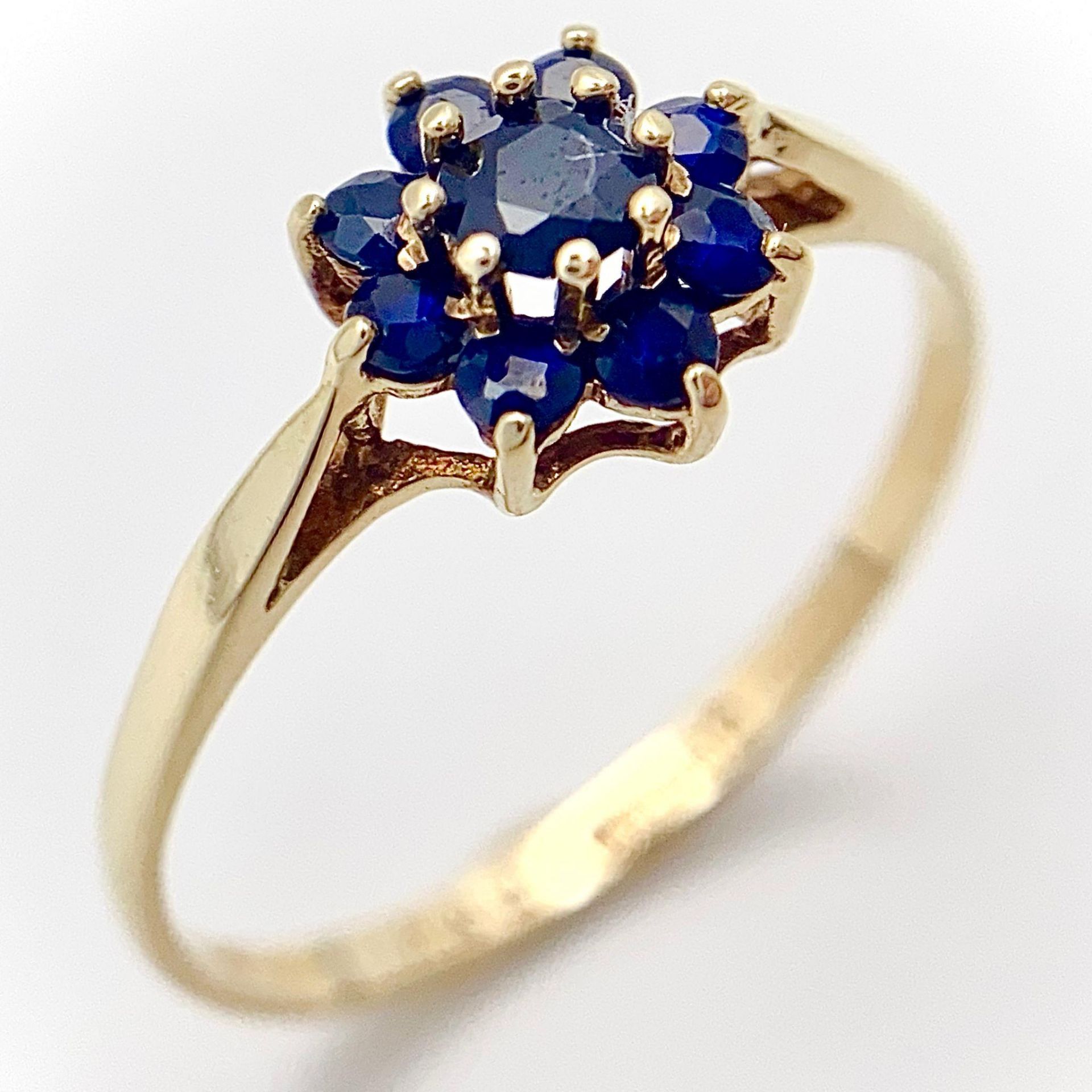 A 9K YELLOW GOLD SAPPHIRE SET CLUSTER RING. 1.3G. SIZE Q.