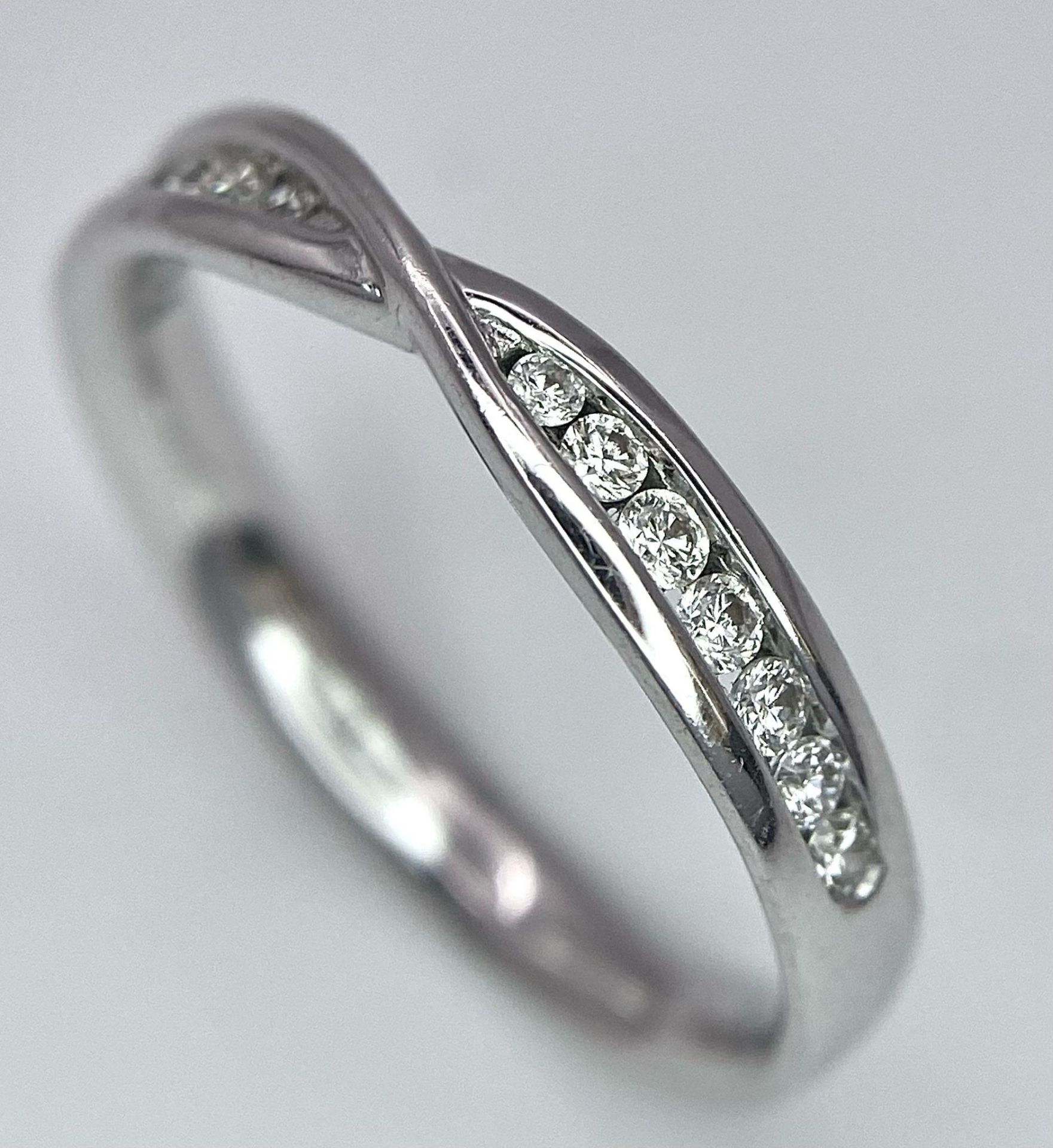 18K WHITE GOLD DIAMOND SET CROSSOVER RING - 0.20CTW. 2.9G. SIZE N.