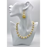 A classy, fresh water cultured white pearl necklace and earrings set, with gold plated parts and